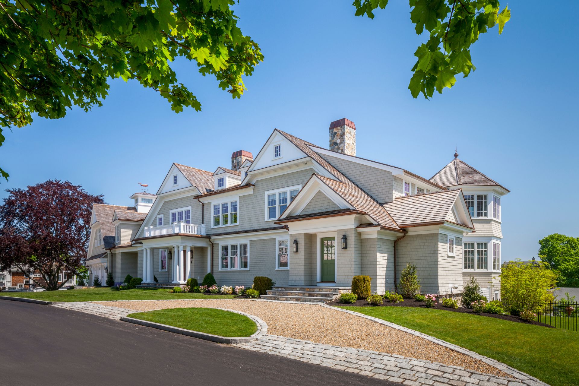 Front elevation of a New England-style home featuring white columns, dormers, and a cedar roof in Hingham, MA
