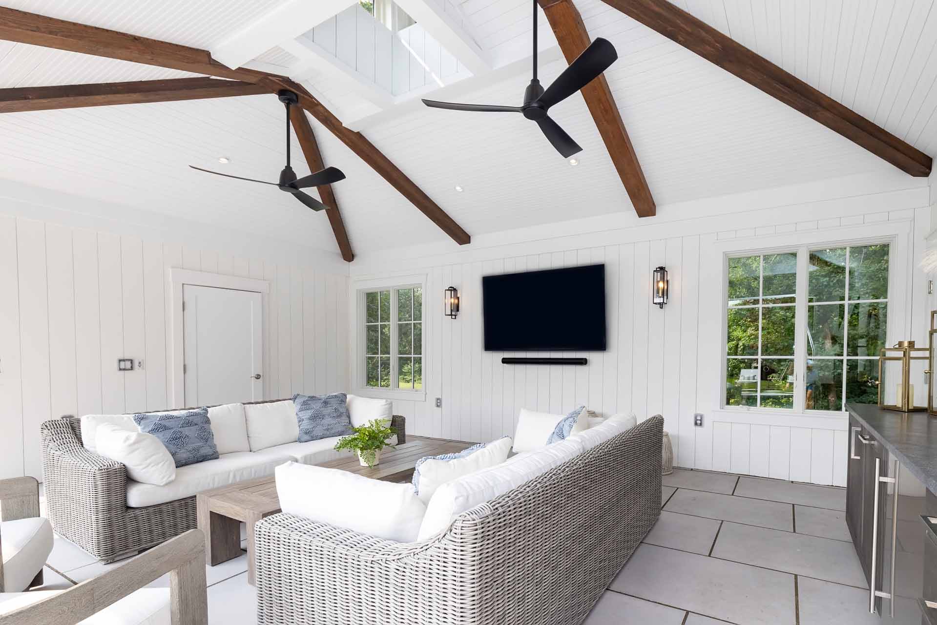 The bar counter and cabinetry continue the pool house's material palette in a soft dove gray.