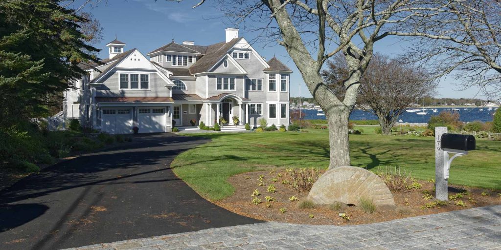 Harbor House sits directly on Scituate Harbor, its cupola, arched entry portico, and circular motor court framed by mature trees and water views.